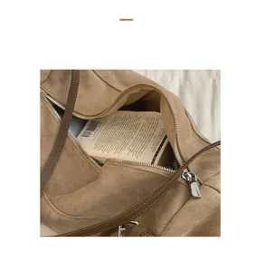 Brown suede shoulder bag interior detail showing spacious compartment and soft fabric lining.