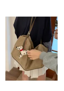 Casual suede shoulder hobo bag detail shot with cute plush puppy pendant accessory.