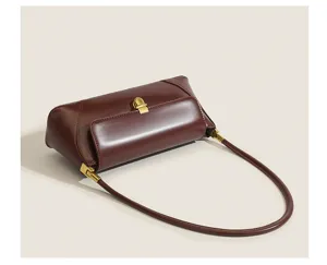 Vintage brown leather underarm baguette shoulder bag, minimalist retro design detail.