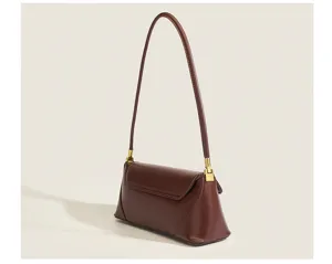 Detailed view of the vintage brown leather underarm baguette bag with elegant gold hardware.