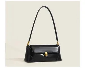 Close-up detail of the black leather underarm bag, showing smooth surface and metal clasp.