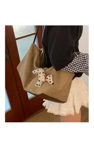 Detail shot of the casual large capacity suede shoulder bag featuring a cute dalmatian plush toy.