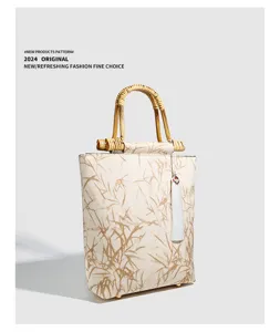 Retro Chinese style bamboo handle canvas handbag with elegant leaf pattern and tassel.