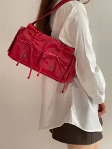 Red patent leather shoulder bag with drawstring bow detail, stylish multi-pocket design.