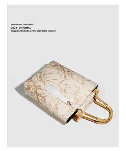 Detailed view of vintage Chinese style bamboo handle handbag with elegant print and white tassel.