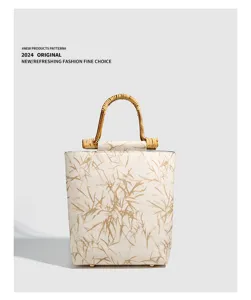 Close-up of vintage Chinese style bamboo handle handbag with elegant leaf print texture.