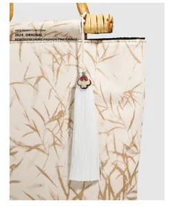 Retro Chinese style bamboo handle handbag with tassel pendant, elegant canvas tote bag detail.