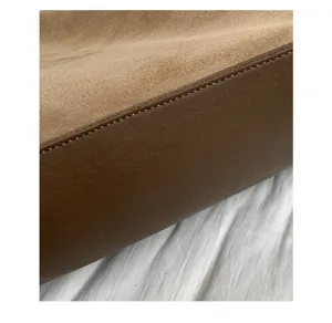 Suede shoulder pillow bag detail showing premium texture, leather trim and fine stitching.