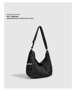 Vista dettagliata della borsa a tracolla nera in denim a pois con design plissettato unico.