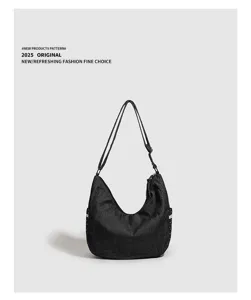 Dettaglio borsa a spalla hobo nera, borsa a tracolla in tela con dettagli a pois ai lati.