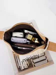 Geweven stro crossbody tas interieur detail toont ruime capaciteit met dagelijkse benodigdheden.