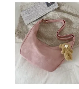 Pink dumpling shoulder bag for women, soft PU leather crossbody bag with cute bear charm.