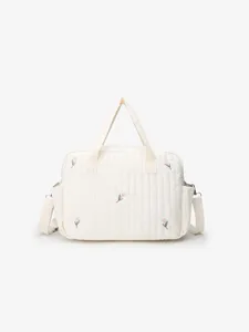 Quilted mommy bag detail showing soft fabric texture, cute tulip embroidery and sturdy handles.