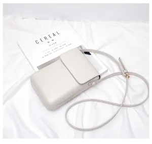 Detail view of white mini crossbody phone bag with slim strap and minimalist design.