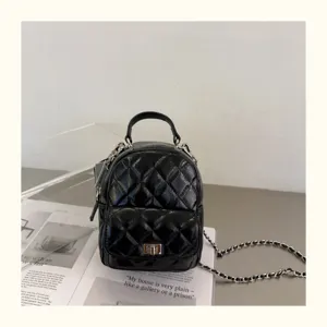 Détail de mini sac à dos matelassé noir, cuir brillant et bandoulière chaîne métallique.