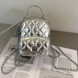 Mini sac à dos matelassé argenté pour femme, chaîne métallique élégante et fermoir tournant.