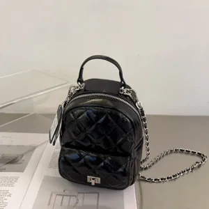 Élégant mini sac à dos matelassé noir pour femme avec chaîne et fermoir tournant chic.