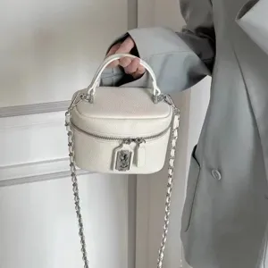 Chic white leather vanity crossbody bag with metal chain strap and top handle for women.