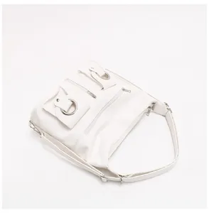 Borsa a tracolla bianca in pelle morbida stile Y2K con tasche multiple e anelli metallici.