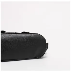 Vista dettagliata del fondo di una borsa in pelle morbida nera con trama fine e precise cuciture.