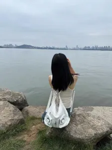 Dettaglio di stile di vita all'aperto con una donna che indossa uno zaino in pelle bianca.