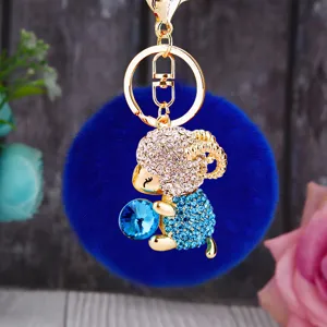 Blue plush pom-pom keychain with rhinestone sheep pendant, cute metal key ring for women bags.