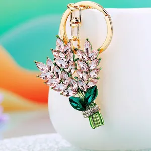 Detailed shot of sparkling rhinestone flower bouquet keychain with pink crystals and gold ring.