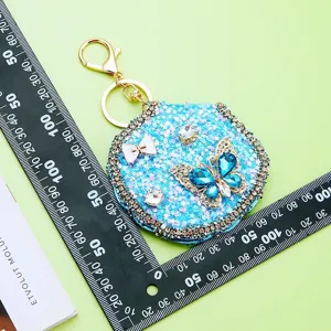 Sparkly blue butterfly compact mirror keychain with rhinestone details and gold clasp.