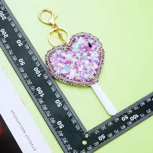 Heart-shaped sequin mirror keychain cute glitter bag pendant sparkling vanity accessory.