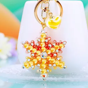 Rhinestone snowflake keychain detail view, sparkling crystal pendant for bags and car keys.