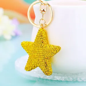 Sparkling rhinestone star keychain bag charm detail close-up showing yellow crystal
