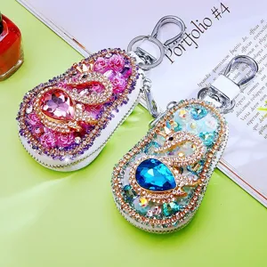 Exquisite rhinestone car key case with sparkling crystals and elegant swan design, durable metal.