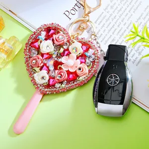 Creative rhinestone heart mirror car keychain with pink handle and decorative flowers.