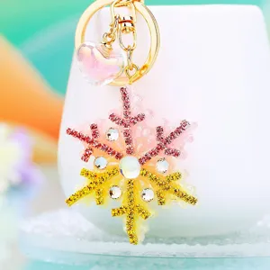 Rhinestone snowflake keychain detail, cute pink and gold crystal bag pendant accessory.