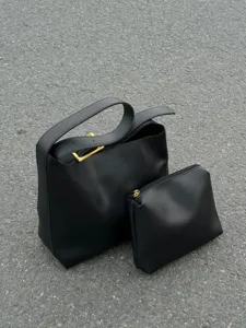 Black leather shoulder bag set with gold hardware, minimalist casual design and spacious storage.
