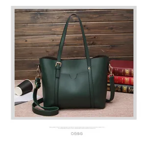 Close-up detail of the dark green leather tote bag featuring adjustable shoulder strap and metal hardware.
