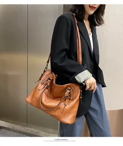 Detail shot of stylish brown PU leather shoulder bag worn by model, showing texture and design.