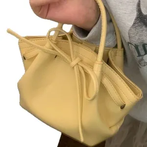Borsa a secchiello gialla da donna con grazioso fiocco e coulisse. Mini borsa elegante.