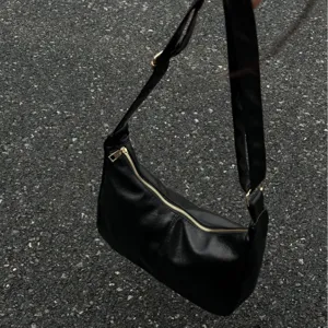 Black faux leather shoulder bag minimalist hobo handbag with zipper closure daily commute.
