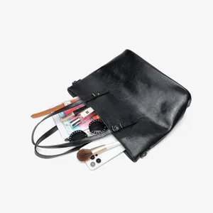 Black leather tote bag interior detail showing large capacity, perfect for daily organization.