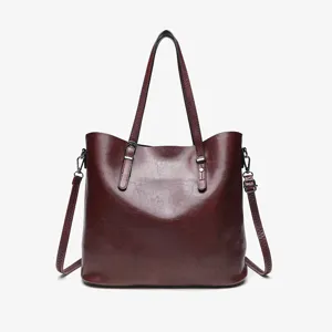 Wine red vintage oil wax leather tote bag detail, elegant shoulder bag with metal buckles.