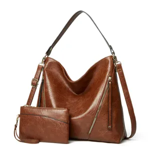 Détail du sac à bandoulière Hobo marron, poche zippée latérale, petite pochette assortie.