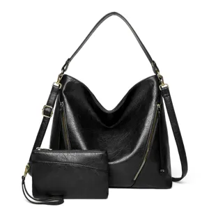 Vue détaillée du sac hobo en cuir noir et de sa pochette assortie avec des fermoirs dorés.