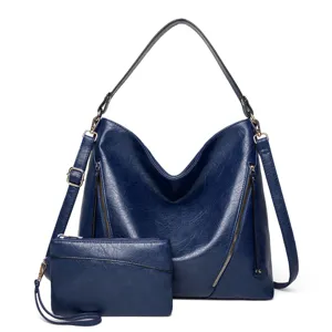 Détail de sac bandoulière hobo bleu foncé montrant une texture en cuir PU et une pochette assortie.