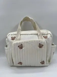 Cute embroidered bear detail view of the stylish white quilted diaper tote bag and mom bag.