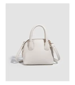 Detailed view of the white dome handbag, featuring stylish top handles and a versatile strap.