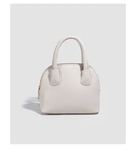 Beige dome handbag close-up, minimalist textured leather handle purse detail shot