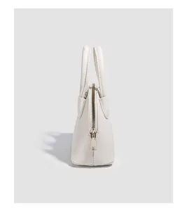 Detailed view of the stylish white dome bag showing its side structure and texture design.