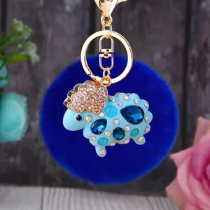 Blue fluffy sheep keychain detailed view, cute plush pom-pom bag charm with rhinestone crystals.