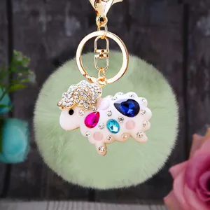 Detailed view of the cute rhinestone sheep plush keychain with gold hardware and fluffy green pom.